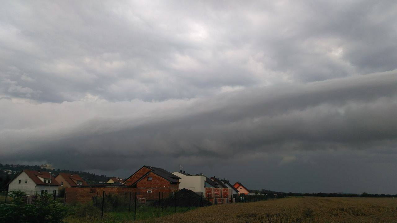 Přicházející bouře nad venkovskou zástavbou