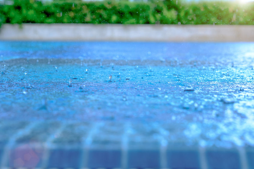 Dopadající kapky deště na rovnou hladinu bazénu