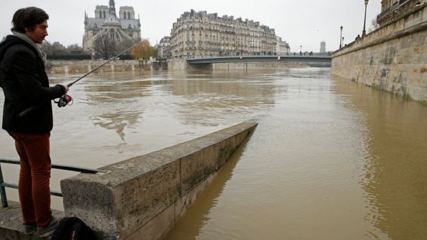 Vysoká voda v Paříži a muž chytající ryby